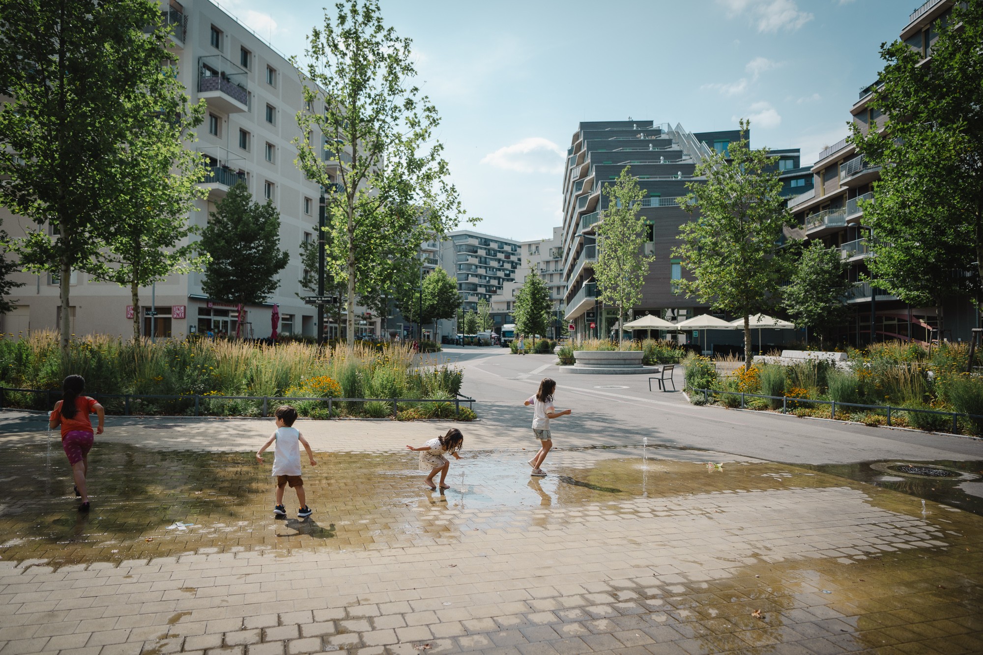 Kinder spielen bei Springbrunnen